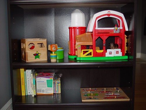 Child's toys neatly arranged on low shelves in the family's living room. (Photo from The Montessori Child at Home)