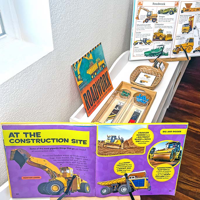 Pages from National Geographic Kids First Big Book of Things That Go with Roadwork Materials in the Background